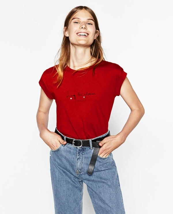 Áo phông màu đỏ tươi với dòng chữ in cuốn hút và cá tính, thường được phối với các loại quần jeans dáng cao
